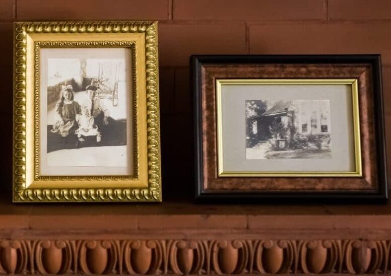 three black and white photos in frames on wood mantle three black and white photos in frames on wood mantle