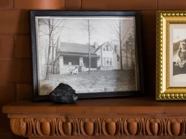 three black and white photos in frames on wood mantle three black and white photos in frames on wood mantle