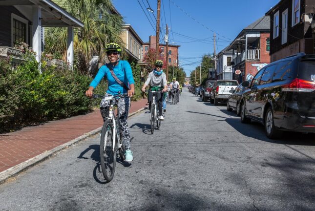 group of people riding bikes down a street