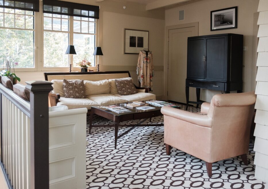 sleek sun room with leather chair, bold patterned flooring, and brown and beige tones