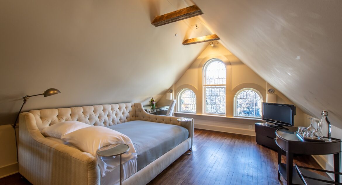 Eaves room with day bed and tv and tv stand in the corner