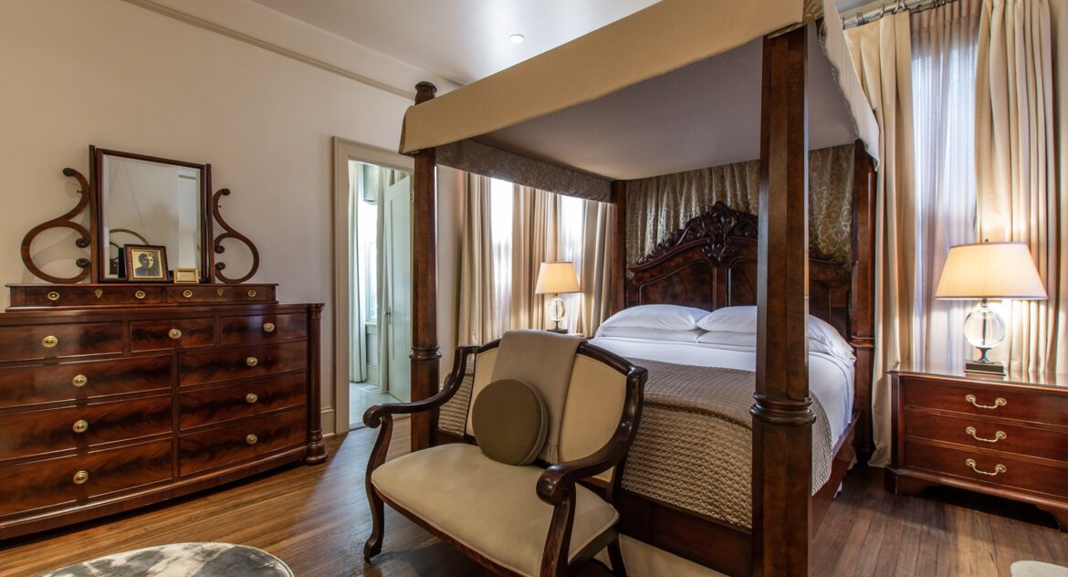 Hinman Suite canopy bed and a wood dresser with a mirror on top