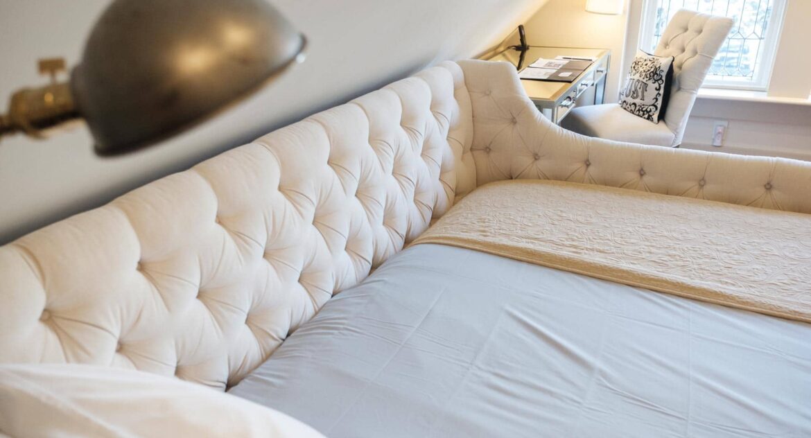 view from atop a guest bed with a desk and chair in the corner