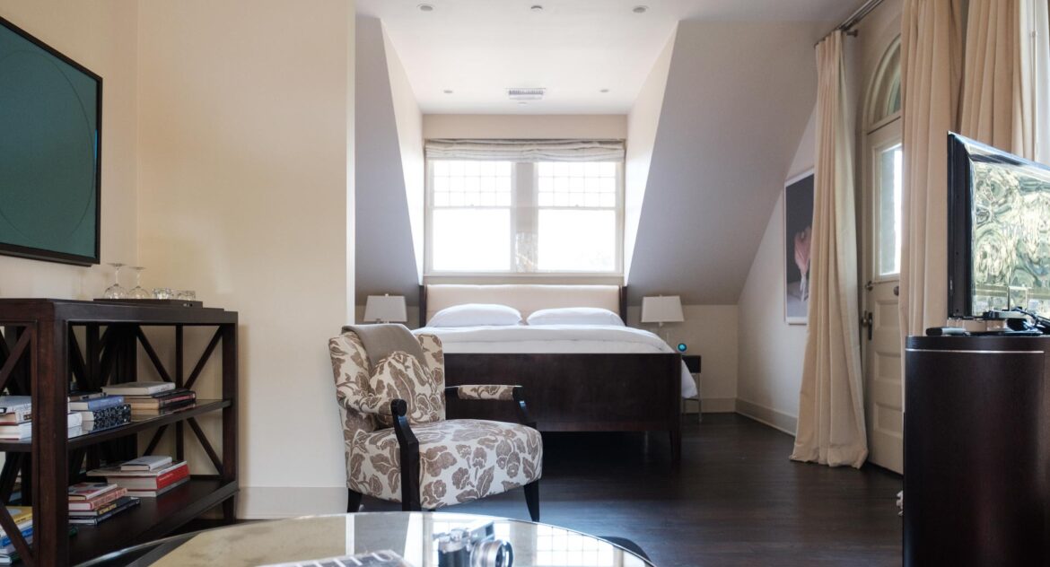 Master Suite mirrored table with flower arm chair and bed in Stonehurst Place