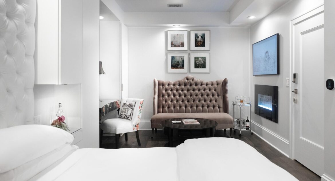 Stedman Suite siting area with velvet couch and white and colored flower chair with desk in Stonehurst Place