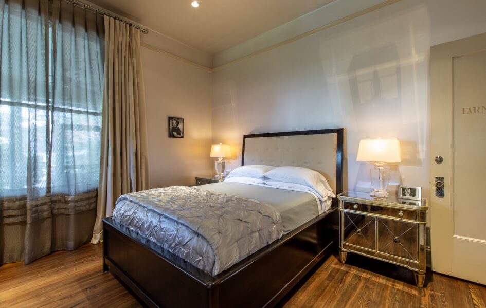 The Farnsworth-Stonehurst Pl-48 Farnsworth room with two mirroed nightstands and a bed with silver metallic comforter