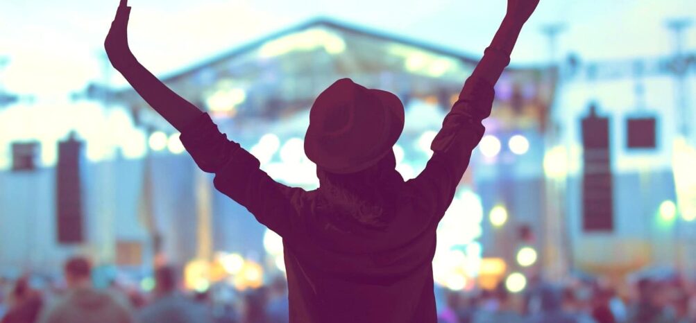 A woman with her hands up at an Atlanta concert