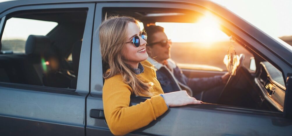 A young man and woman in a car on a Houston to Atlanta road trip