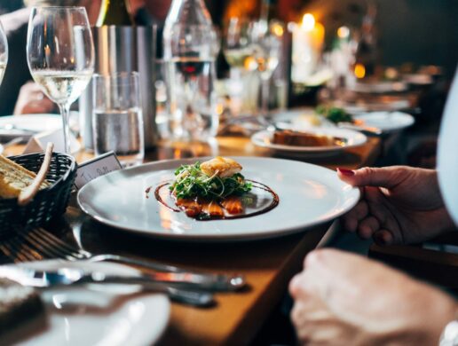 upscale long table with white plate and green salad and fish